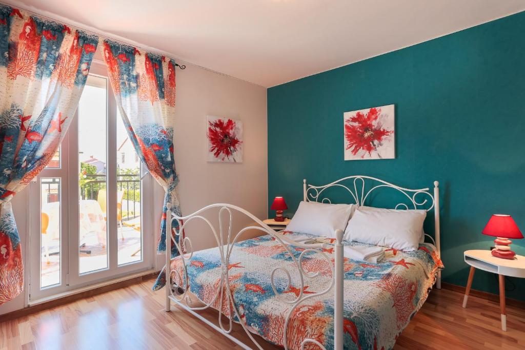 Spavaća soba s tirkiznim zidom i izlazom na balkon