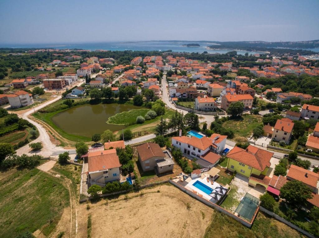 Zračni pogled na Medulin, okolne kuće s bazenima i more u pozadini